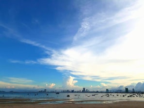 A coastal cityscape with a clear sky, boats on the water, and a distant skyline. - AVA Hotel & Apartment (Da Nang)