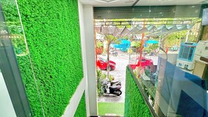 Una scala con pareti di prato sintetico verde che conduce a un’area esterna con auto parcheggiate e un veicolo blu.