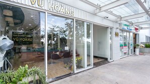 A modern hair salon with a glass facade and a sign reading "VÜ HOÀNG".