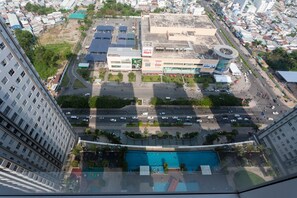 A high-rise hotel with multiple floors, a swimming pool, and a parking lot. - Jennifer Luxury Apartment 2BR 18TH (Ho Chi Minh City)