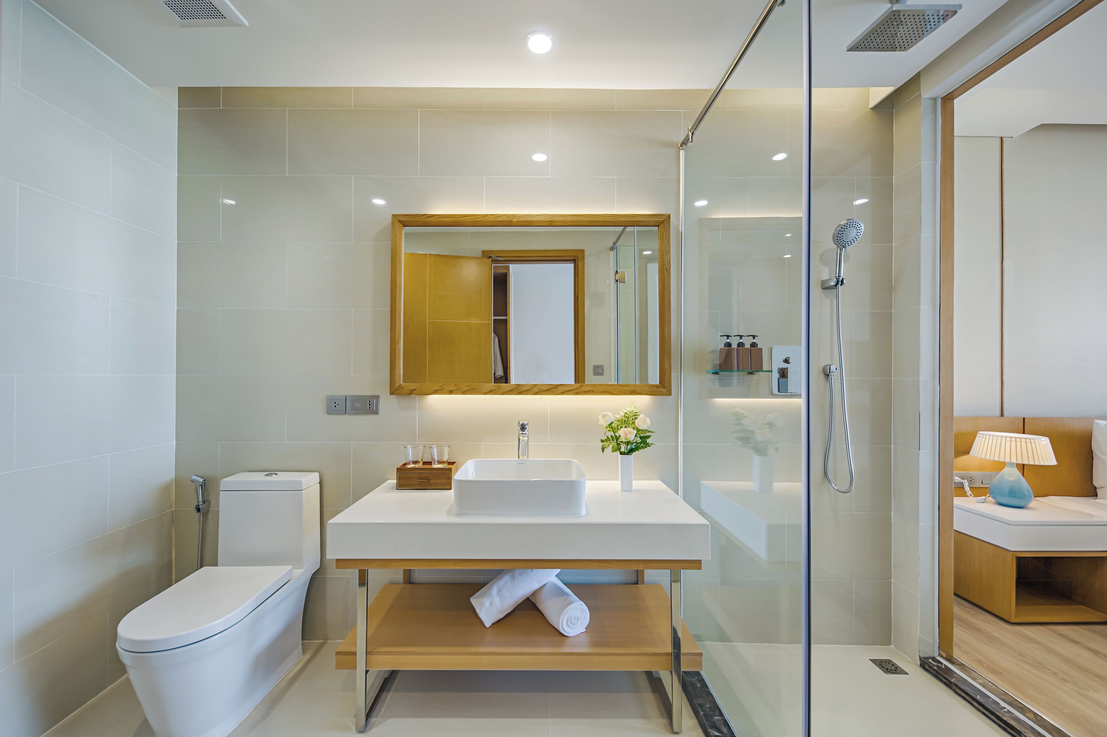 Een moderne badkamer met toilet, wastafel en douche.