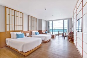 A hotel room with two beds, a desk, and a view of the sea. - TMS Hotel Da Nang Beach (Da Nang)