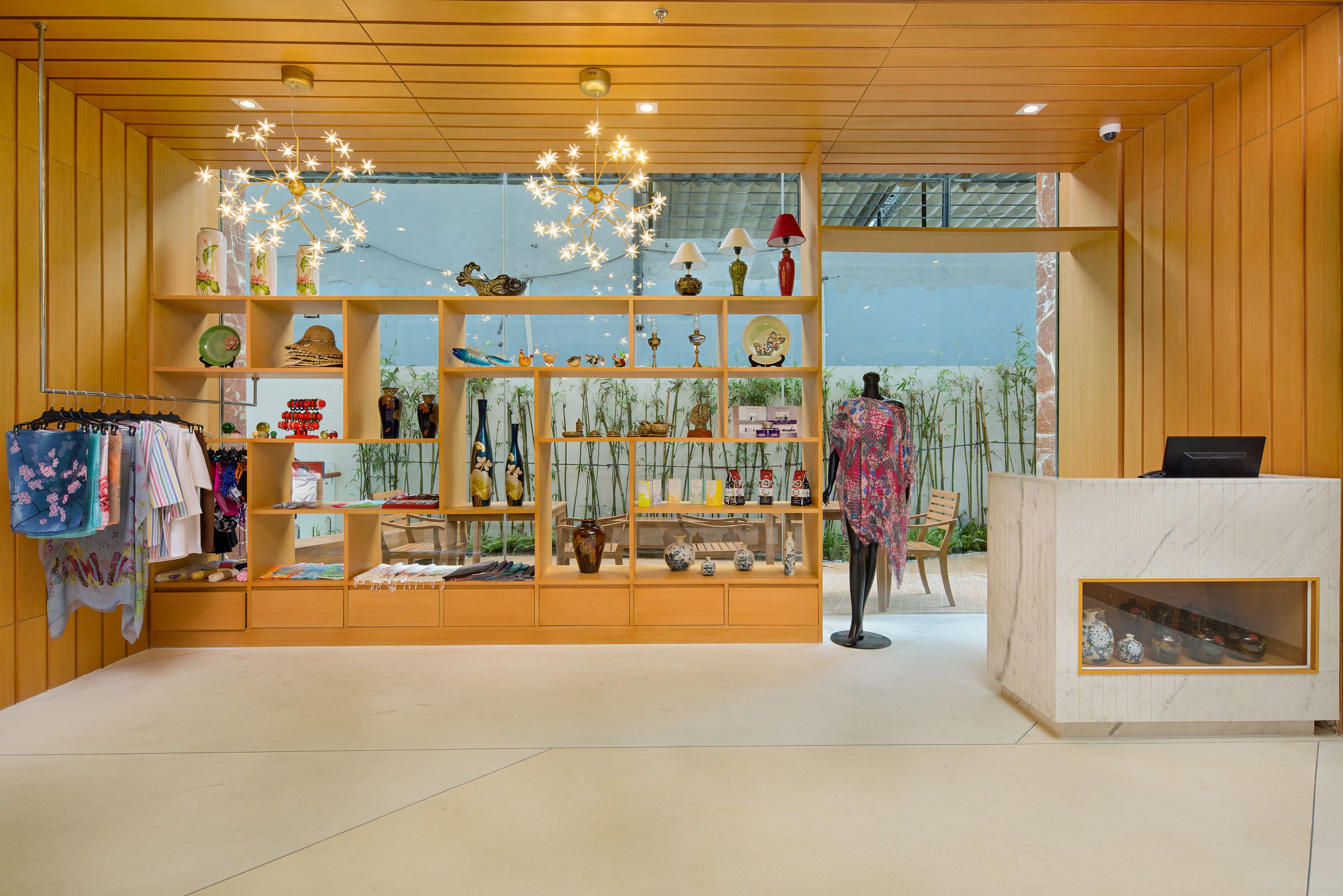 A boutique store with wooden shelves displaying various items, a mannequin, and a reception desk.