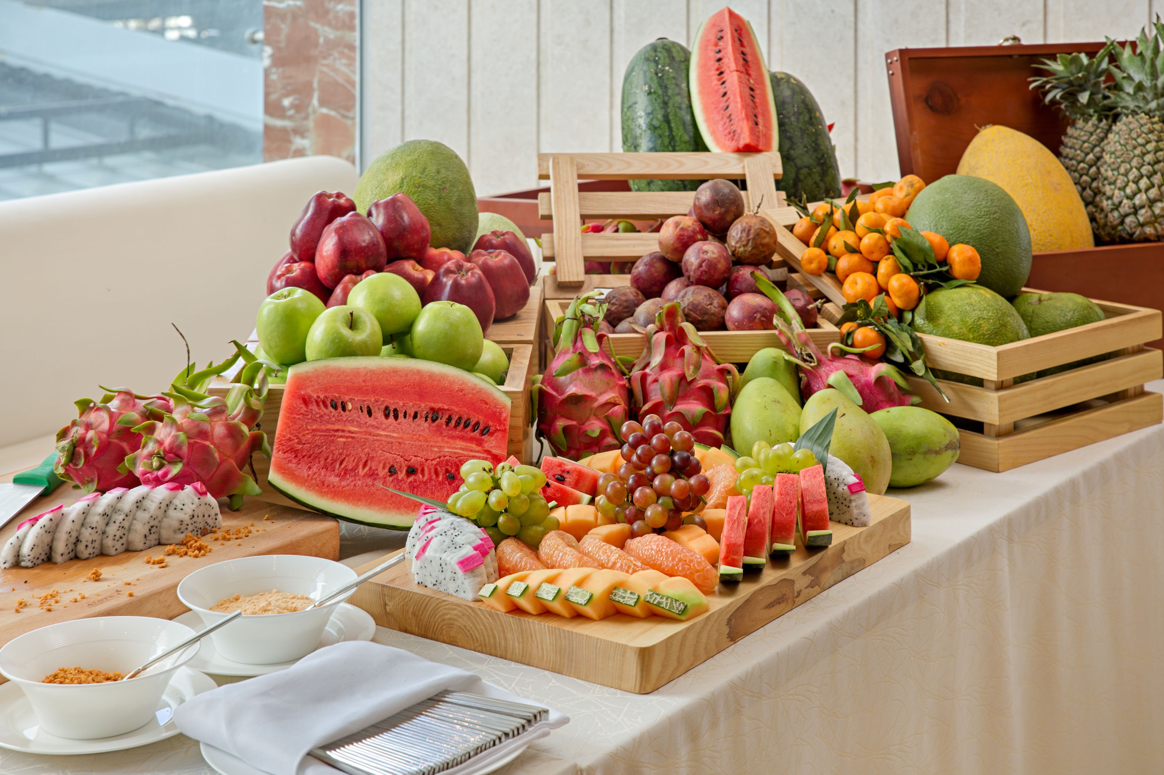 Une présentation de fruits comprenant différents types de fruits et une pastèque servant de pièce maîtresse.