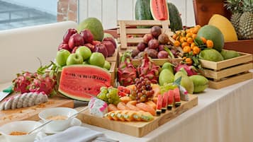 Une présentation de fruits comprenant différents types de fruits et une pastèque servant de pièce maîtresse.