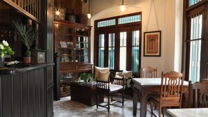 A traditional library with wooden bookshelves, a reading chair, and a table.