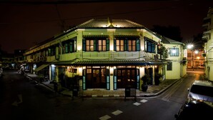 A traditional building with multiple stories, a tiled roof, and a street in front.