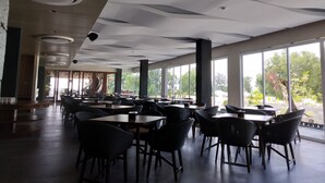 A spacious indoor area with tables and chairs arranged for dining. - Quins Style Resort Belitung (Tanjung Pandan)