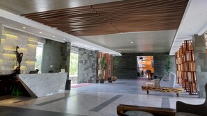 A spacious lobby with a reception desk, seating area, and a modern ceiling design. - Quins Style Resort Belitung (Tanjung Pandan)
