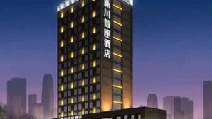 A modern high-rise hotel with a prominent vertical sign, multiple floors, and a well-lit facade. - Xinchuan Shouzuo Hotel (Mianyang)