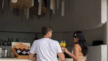 A bar area with wooden chairs and a thatched roof.