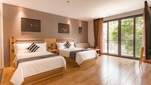 A hotel room with two beds, a large window with a view, and a balcony.