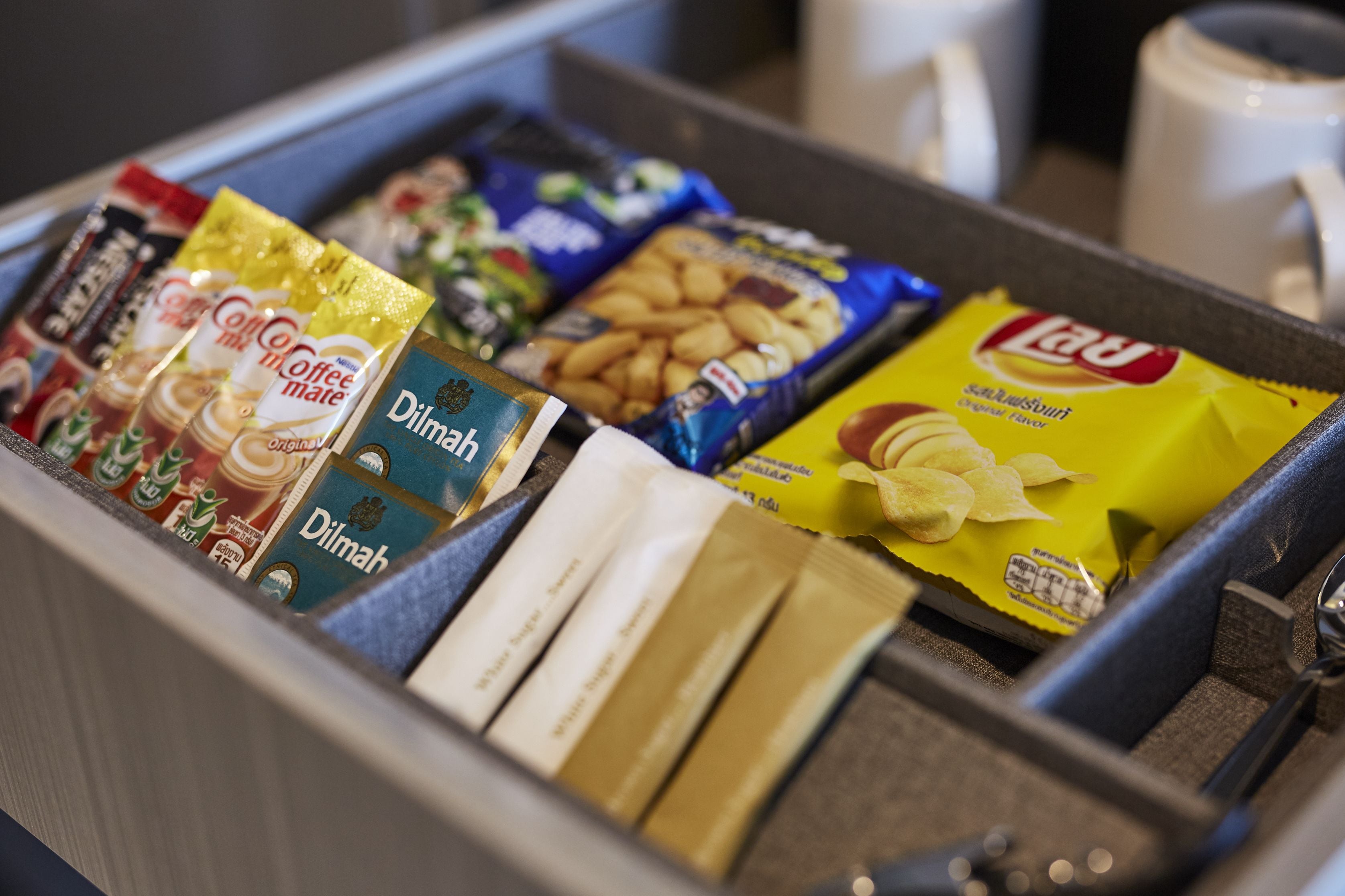 Un cajón con diversos productos alimenticios, como café, galletas y aperitivos.