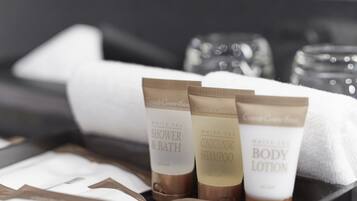A tray with three toiletry items: shower & bath, conditioning shampoo, and body lotion.