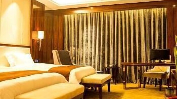 Ein Hotelzimmer mit einem großen Bett, einem Schreibtisch und einem Stuhl.
