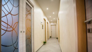 A hallway with doors, a phone, and small potted plants. - B&B Pepito (Cefalù)