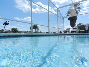 A swimming pool with clear blue water, surrounded by a white metal structure, palm trees, and lounge chairs. - Sm215676 - Espirit - 4 Bed 3 Baths Villa (Davenport)