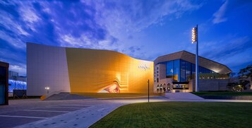 Un bâtiment moderne doté d’une façade incurvée et d’une grande entrée.