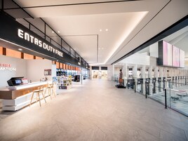 A spacious, modern shopping mall with a 'Free' sign, a food court, and a 'Duty Free' section.