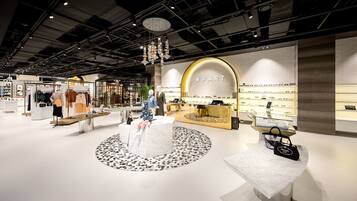 A modern retail store with mannequins displaying clothing and jewelry.