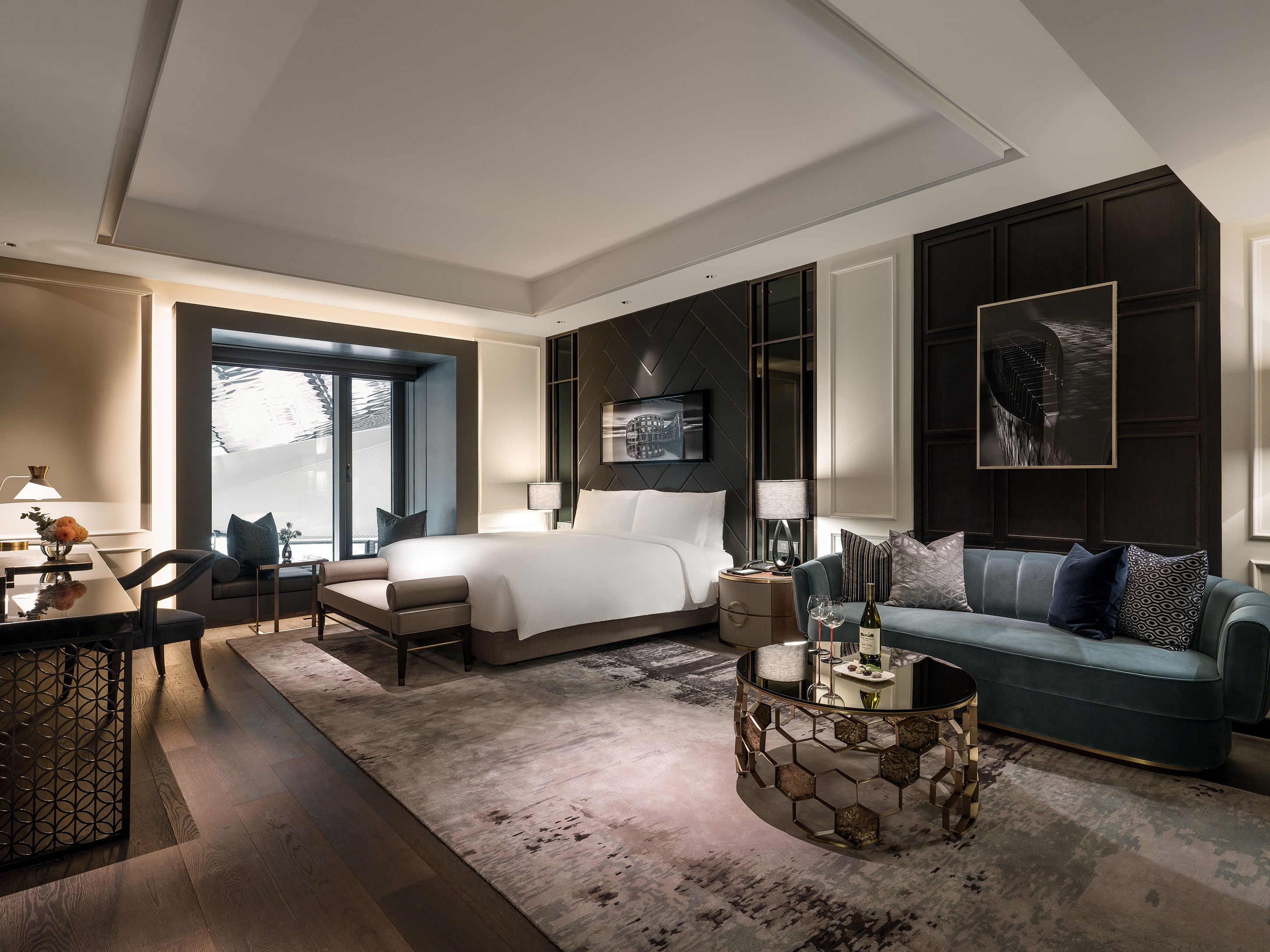 Une chambre d’hôtel moderne dotée d’un grand lit, d’un canapé, d’un coin repas et offrant une vue sur l’extérieur.