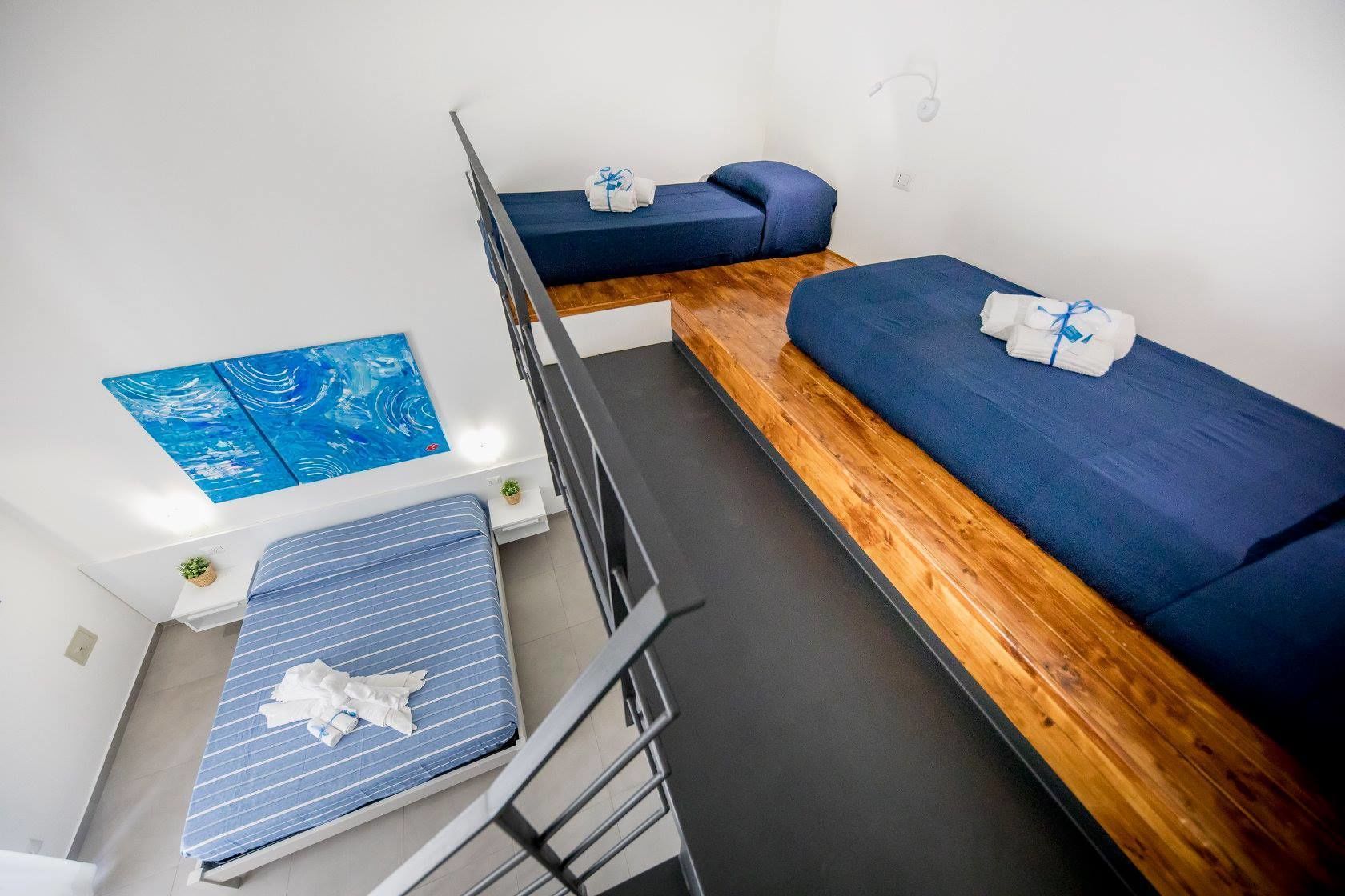 Un dormitorio con literas, una mesita pequeña y un estante en la pared.