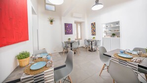 A modern dining area with two tables, chairs, and pendant lights. - Pepito Palace (Cefalù)