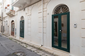 Traditional European-style buildings line the cobblestone street, each with an arched window and decorative door.