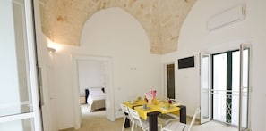 Enjoy meals on the dining table set with comfortable seating for two, overlooking the balcony.
