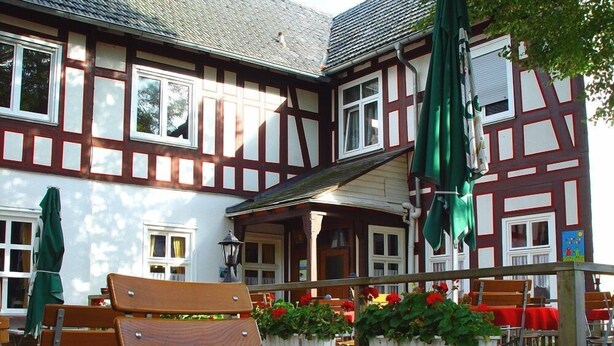 Un bâtiment traditionnel à colombages, doté d’un balcon, d’un espace extérieur aménagé pour s’asseoir et d’un vélo.