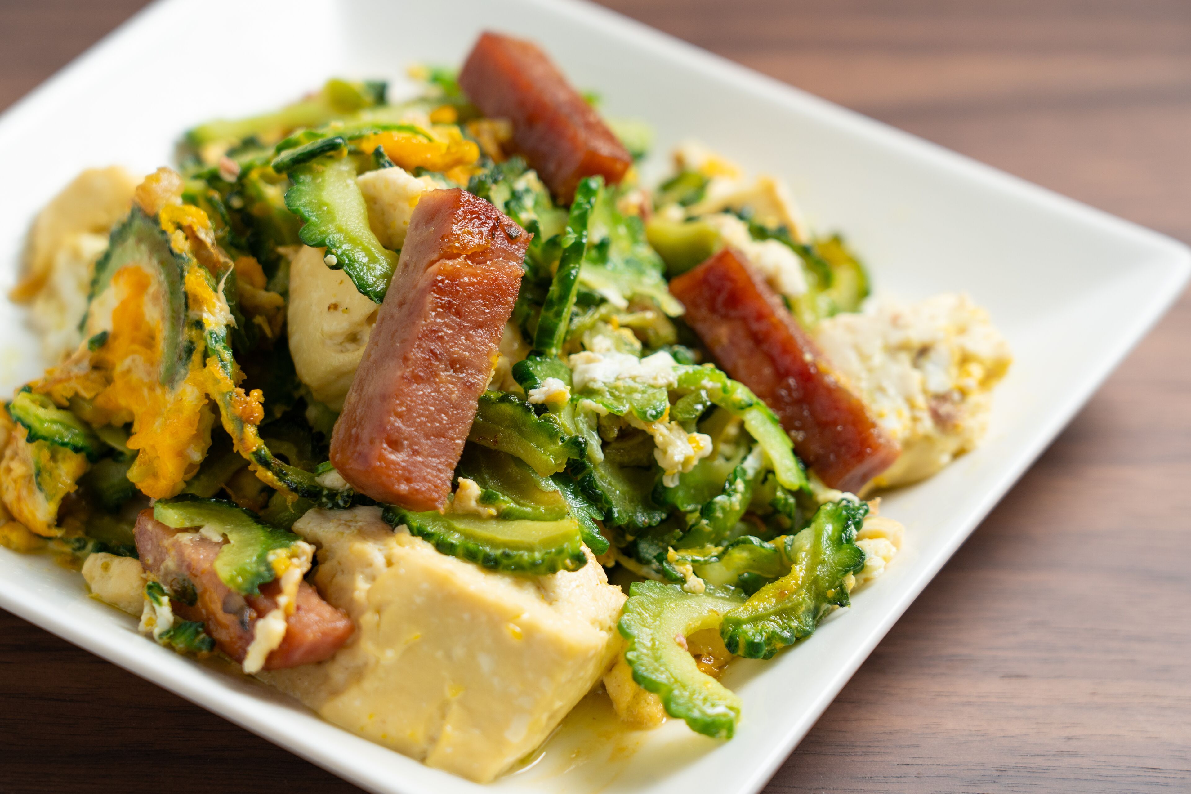 A dish with various vegetables and meat on a white plate.