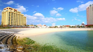 Ein Strandhotel mit Sandstrand und klarem Wasser.