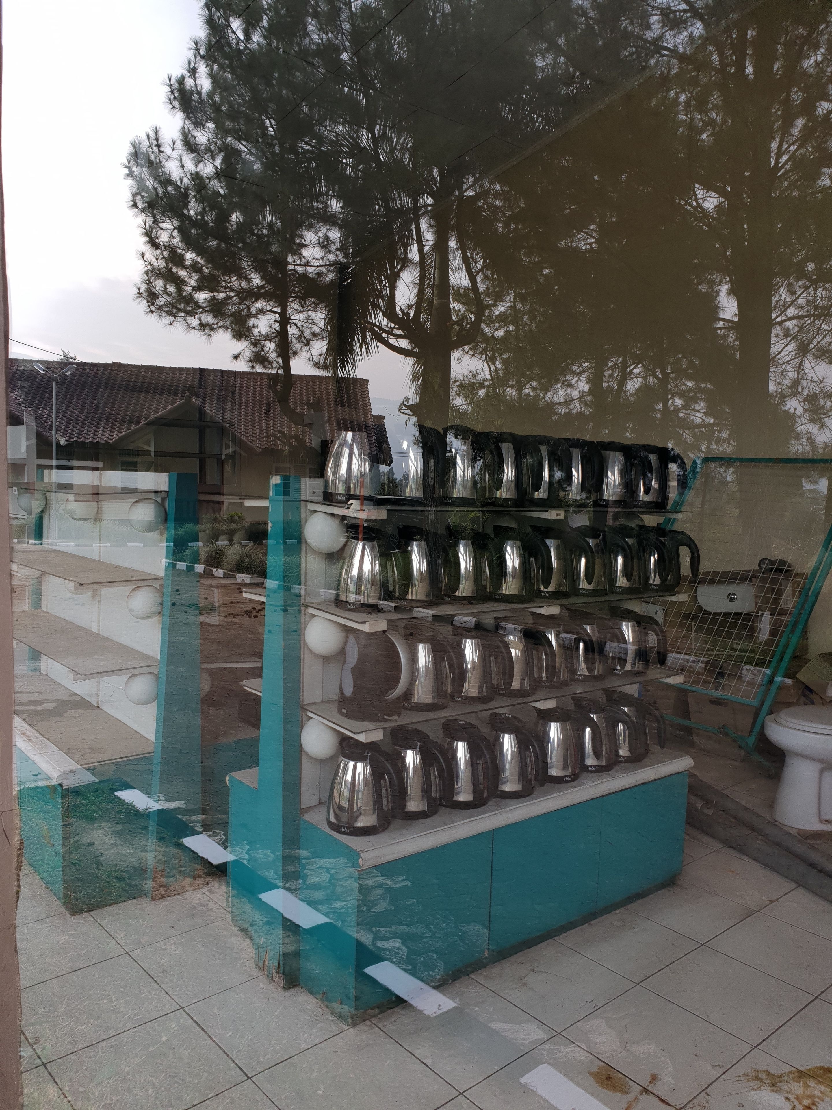 A display of stainless steel kitchenware, including pots and pans, arranged on shelves.