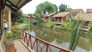 Une vue sur la rivière, avec des bâtiments en bois, un balcon doté d’une balustrade et un banc.