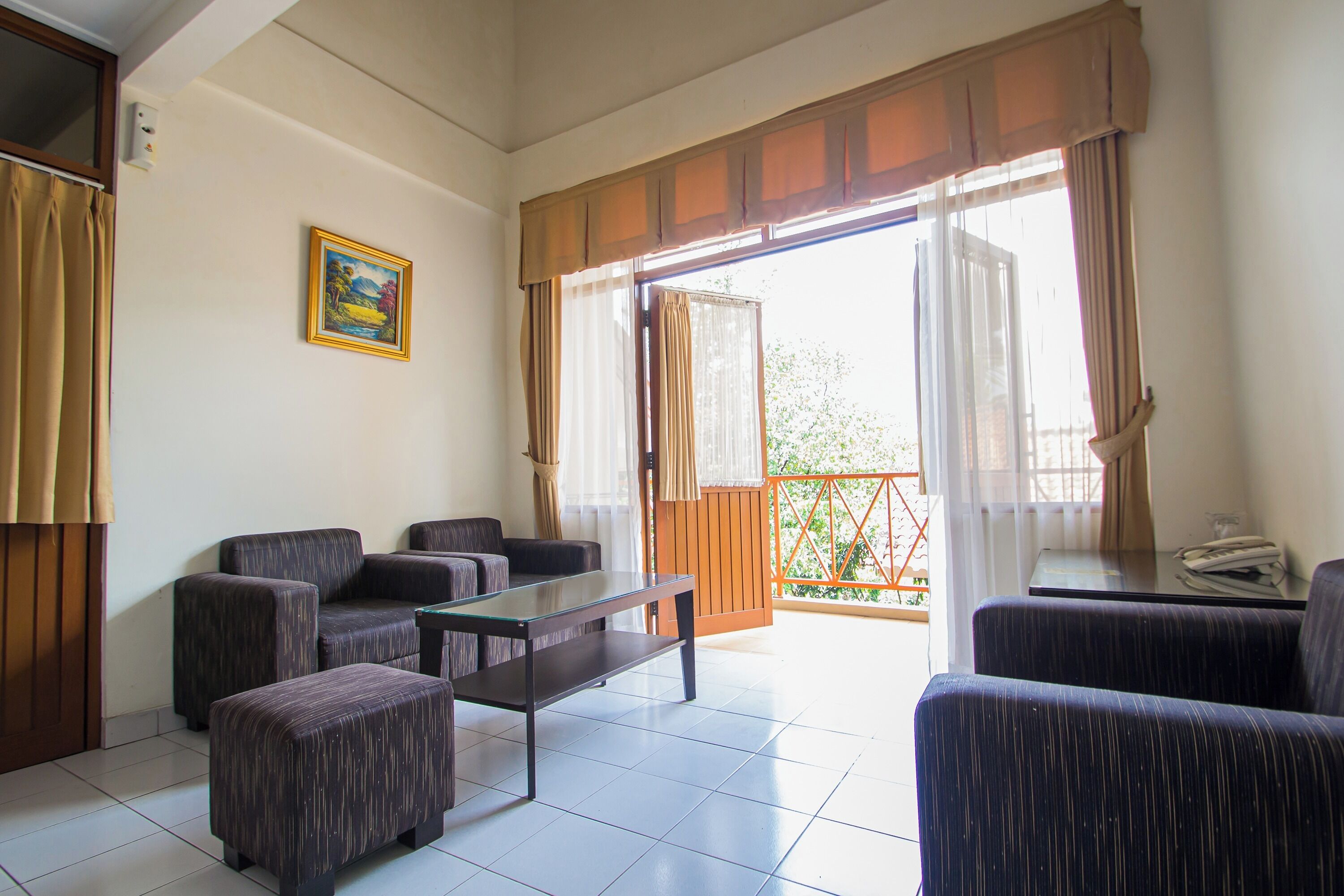 A room with a sofa set, a small table, and a view through a large window.