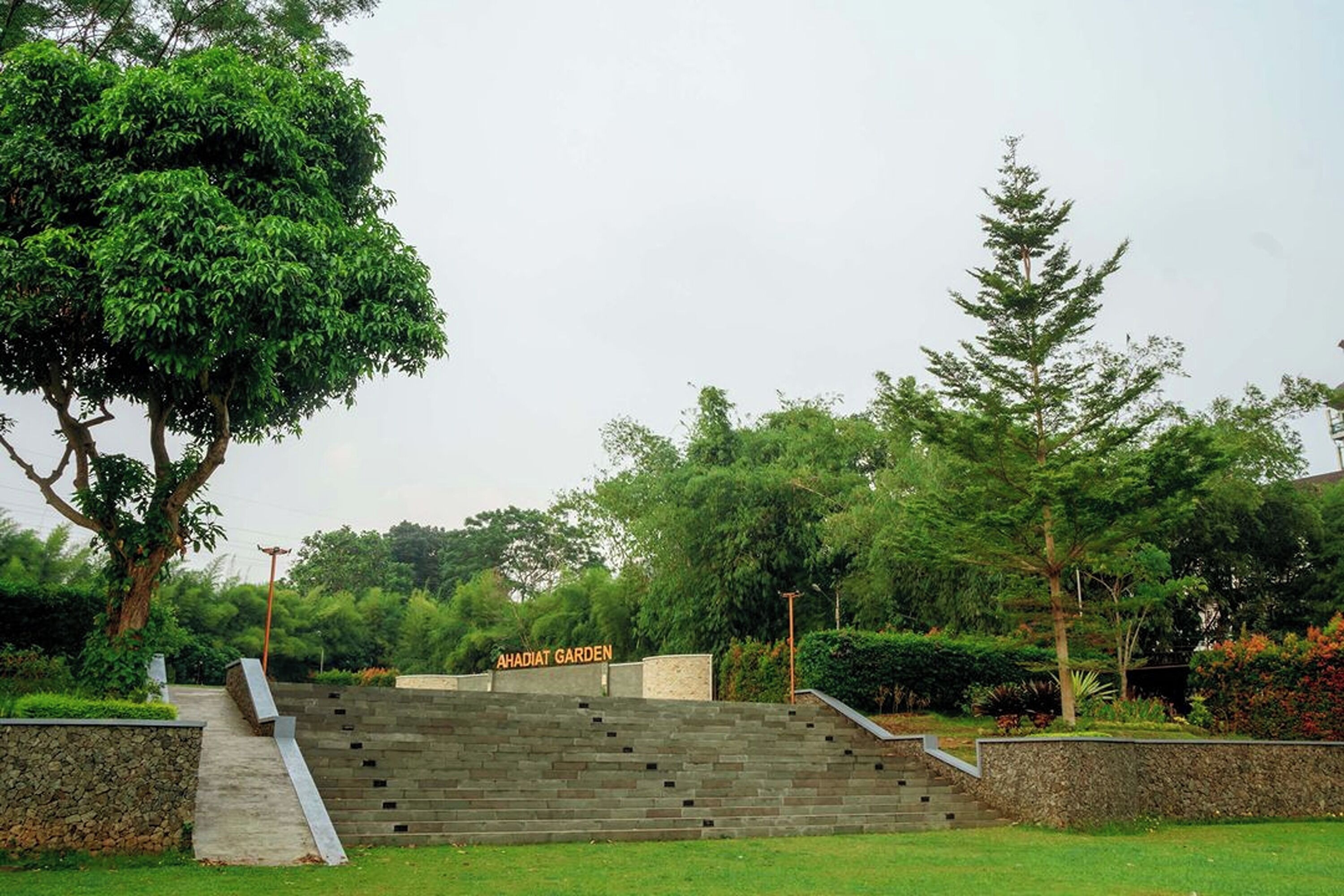 A stone staircase leading to a garden area with a sign reading "AHADIAT GARDEN".