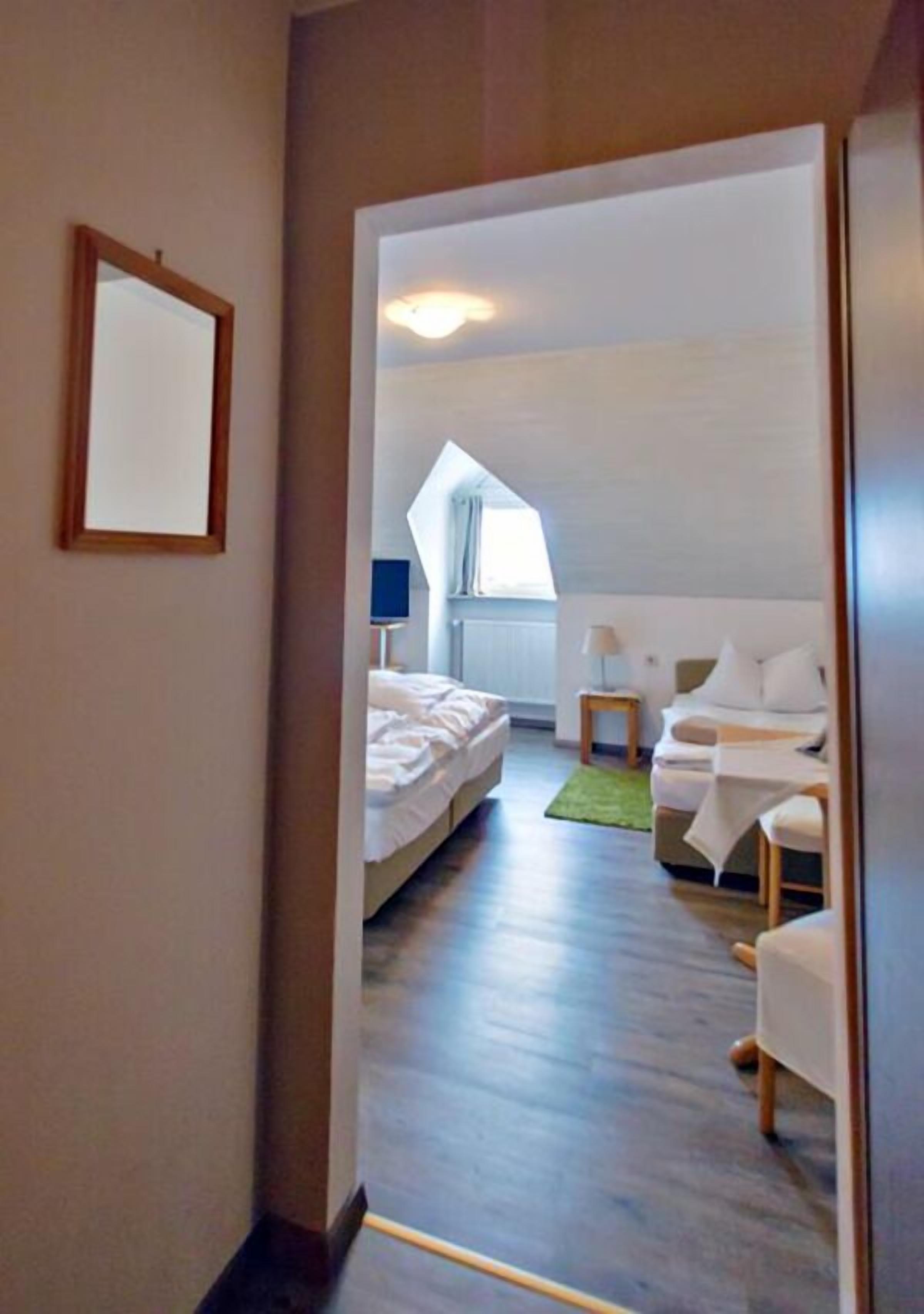 Habitación de hotel con una cama, un sofá, una mesita y una ventana.