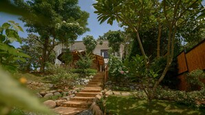 A stone staircase leading to a building surrounded by lush greenery and a wooden fence. - Hilltop Pool and Villa (Puerto Princesa)
