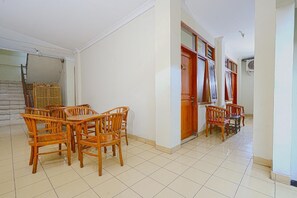 A spacious room with a tiled floor, wooden furniture, and a door with a number sign. - Hotel Astria Graha (Bandung)