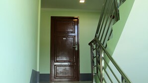 Una escalera con barandilla de metal y una puerta de madera en la parte superior.
