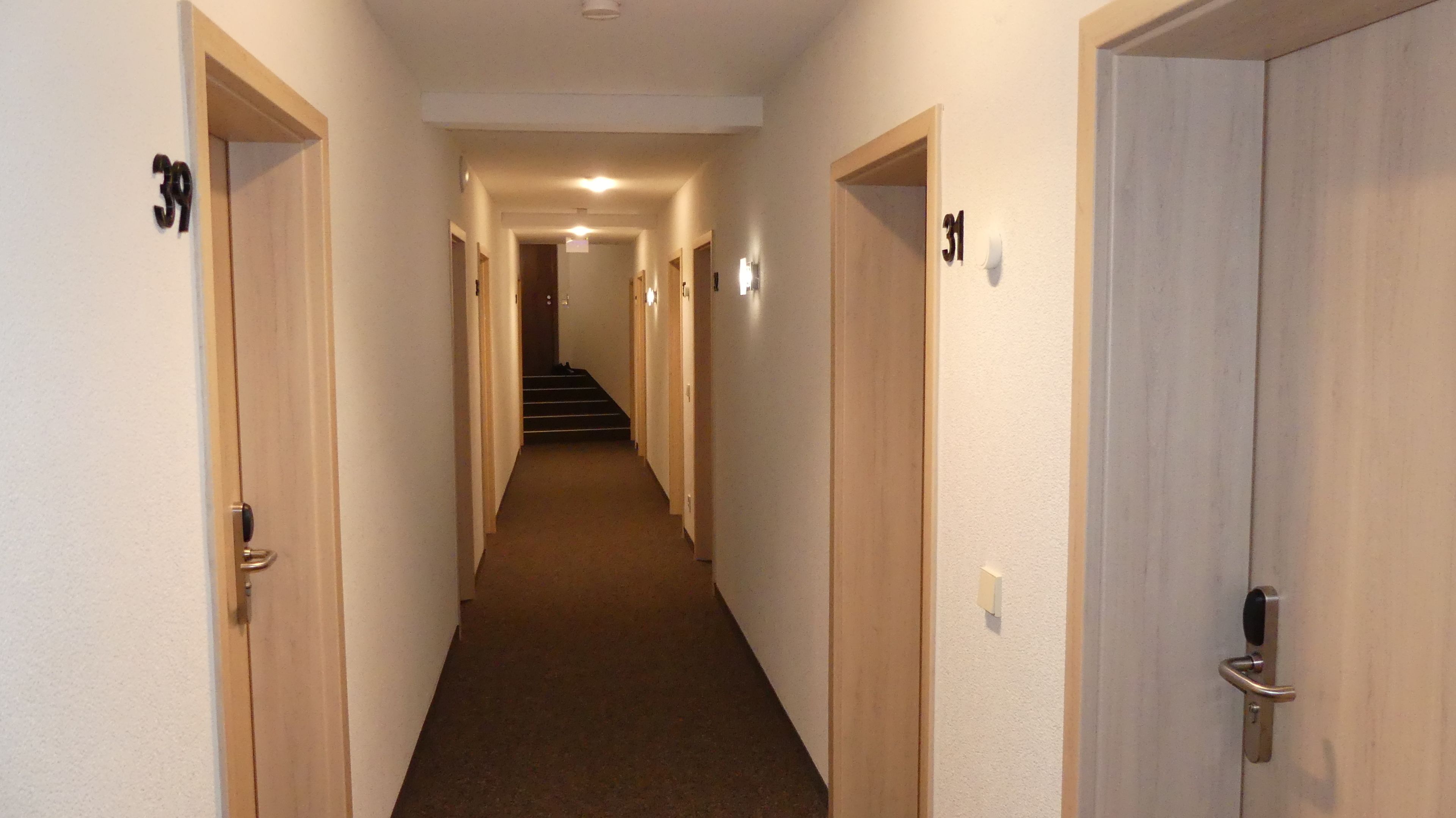 Ein schmaler Flur mit den Nummern 39 und 31, der zu einer Treppe führt.