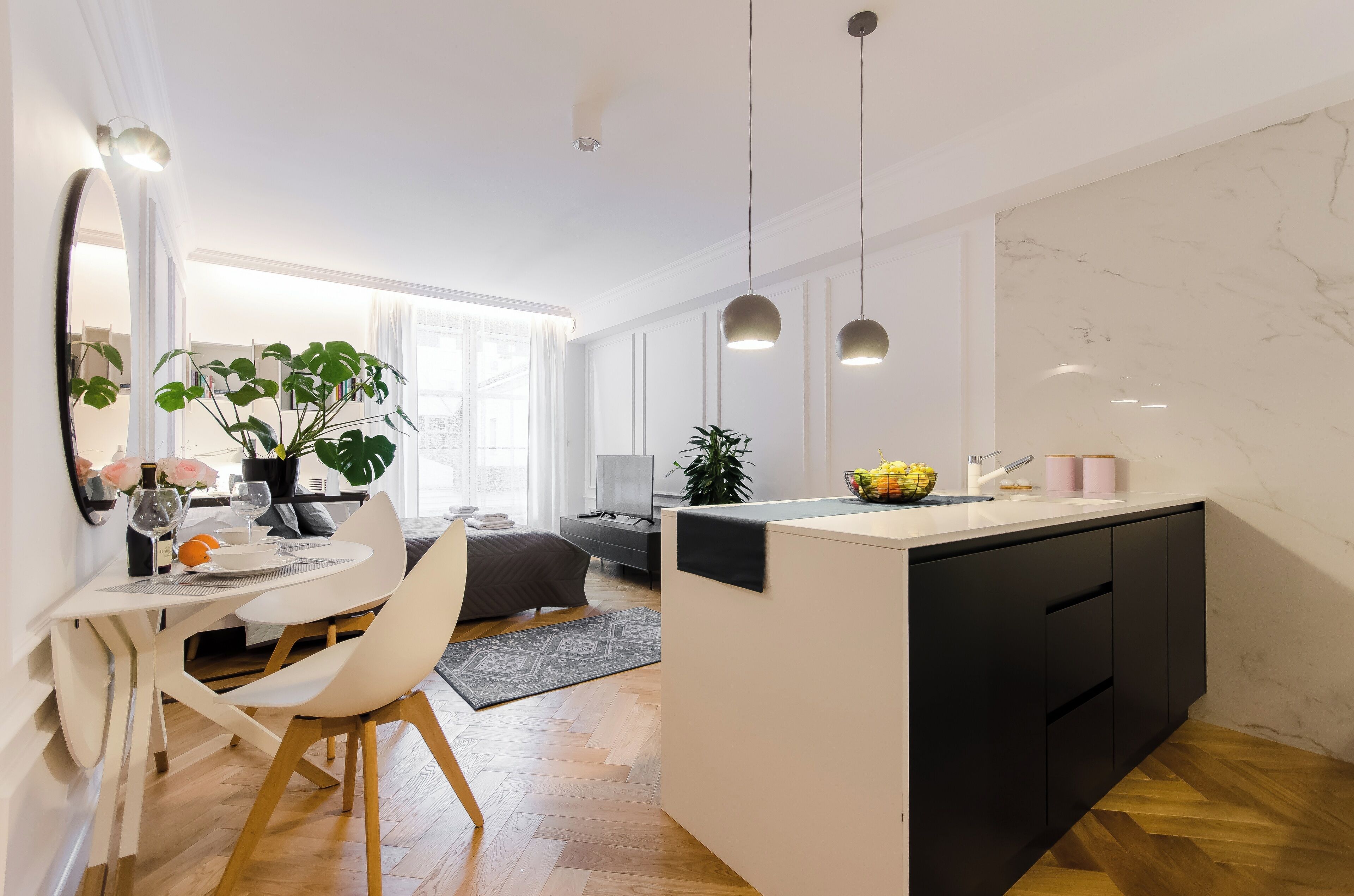 A modern kitchen with a central island, white cabinetry, and pendant lighting.
