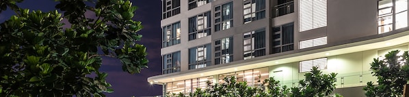 A modern building with multiple floors, large windows, and a well-lit entrance area.