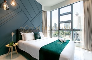 A modern hotel room with a large bed, a view of the city, and a unique geometric wall design.