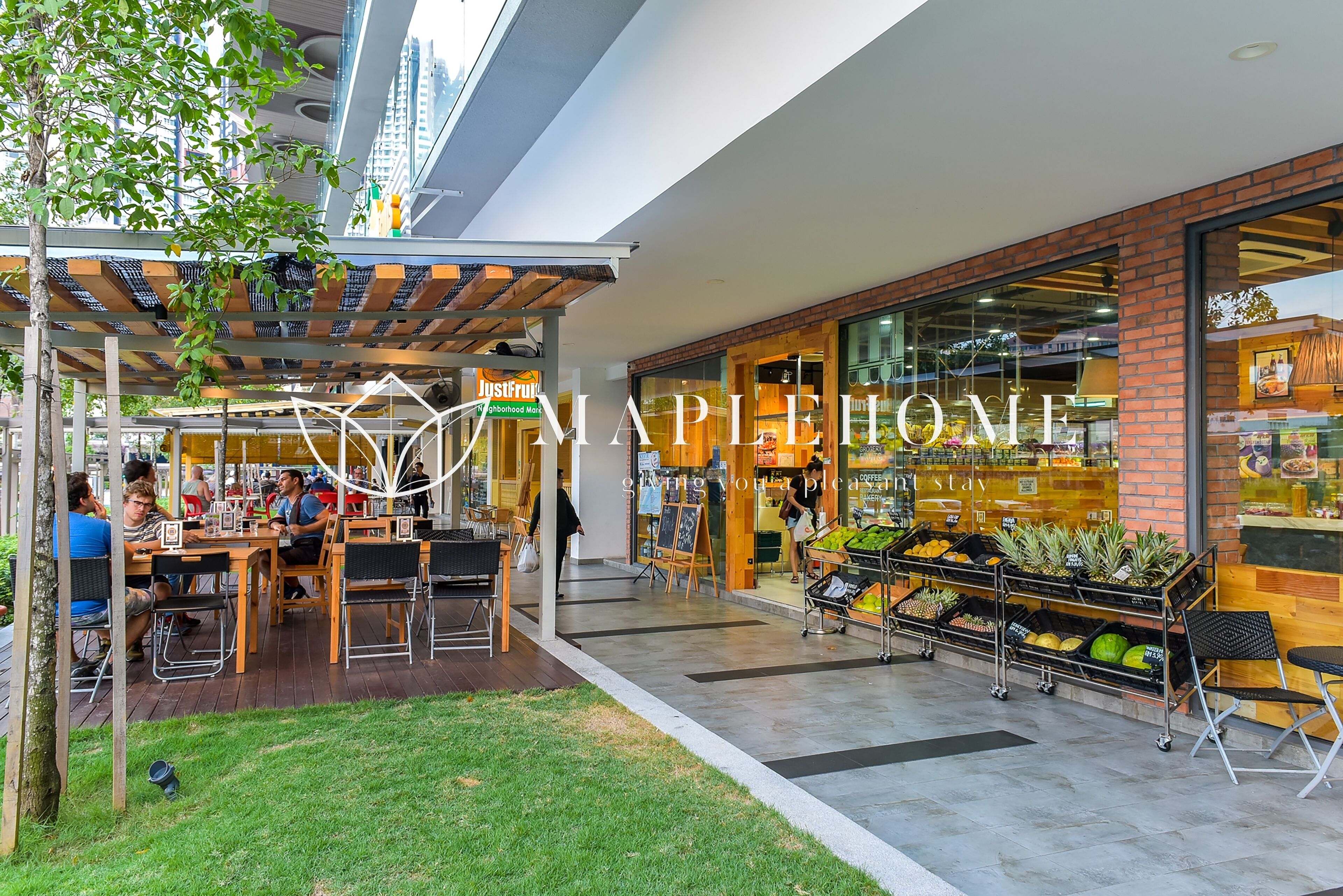 An outdoor seating area with tables and chairs, a fruit stand, and a restaurant entrance.
