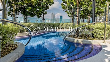 Una piscina al aire libre, sombrillas, sillones reclinables de piscina