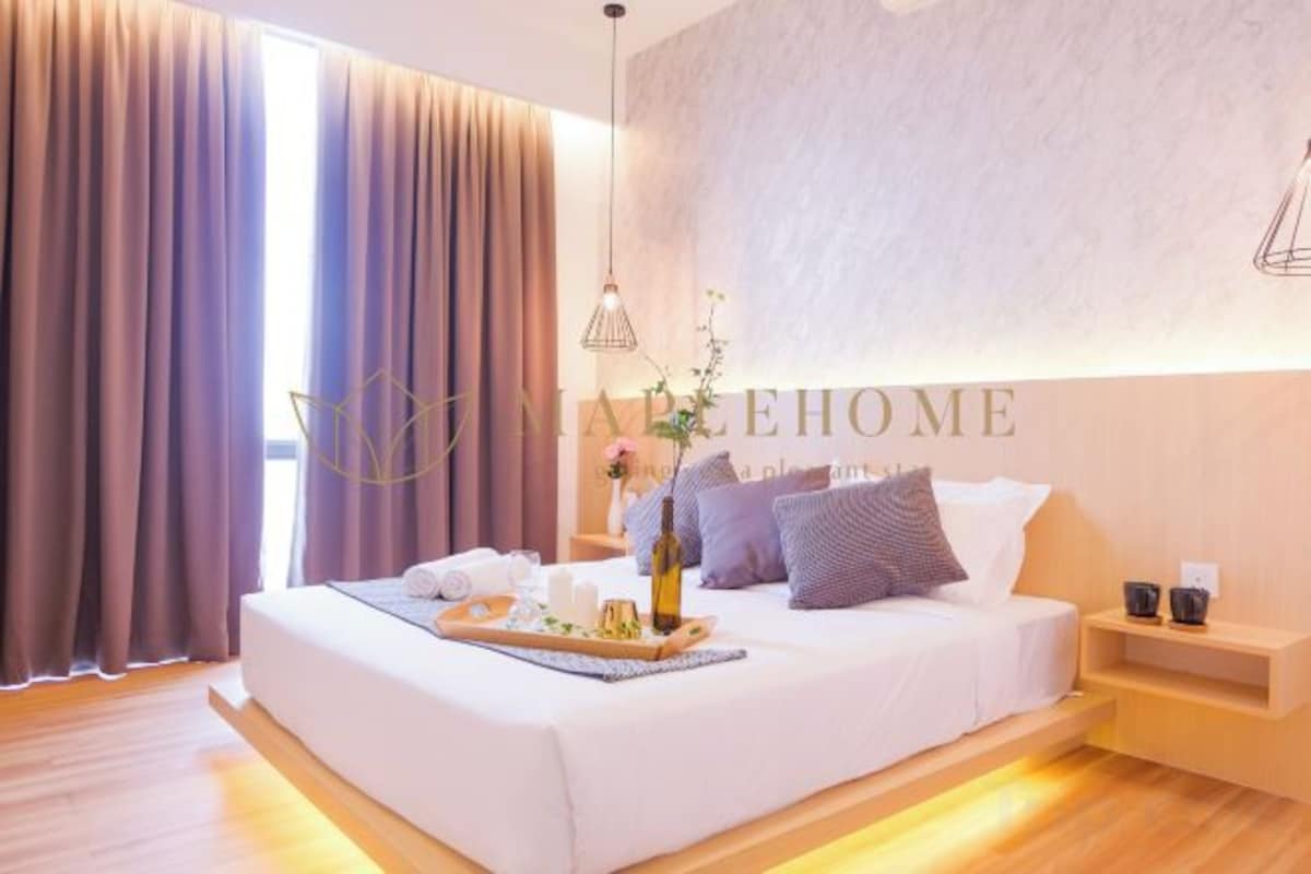 A modern bedroom with a large bed, a bedside table, a nightstand, and a wall-mounted light fixture.