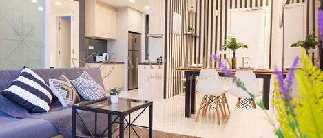 Una sala moderna con sofá, mesa de centro y comedor con sillas.