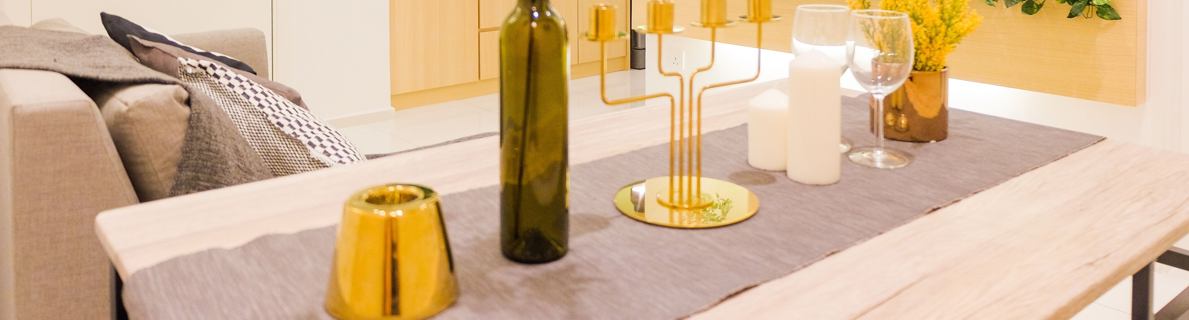 Una mesa para comer con un candelabro, una botella de vino y una copa.