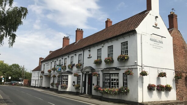 A traditional white building with multiple windows and flower boxes, labeled "Angel Inn." - The Angel Inn (Worksop)